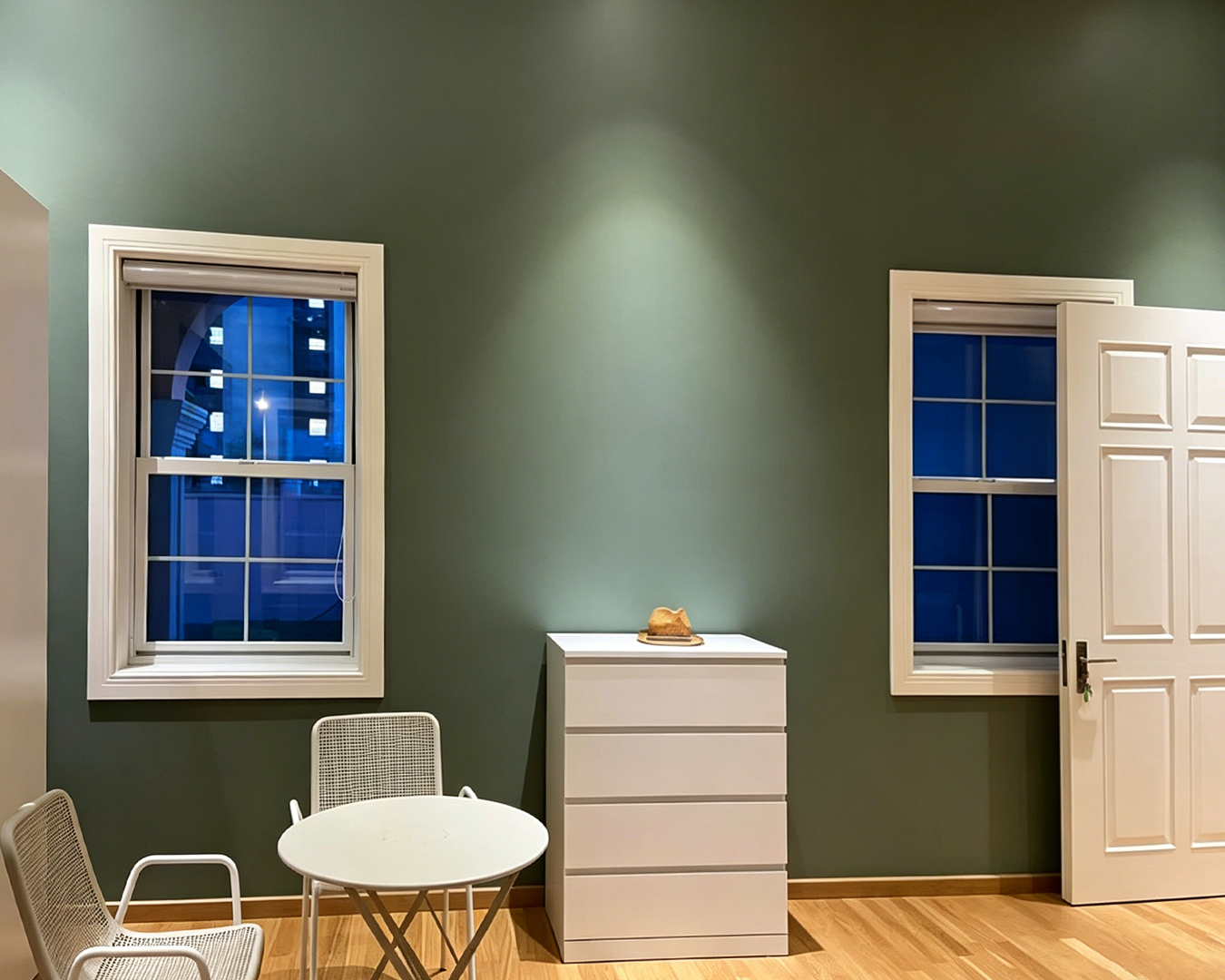 Georgia Windows & Doors white aluminum double hung sash windows with colonial grid bars — bedroom pair sage green wall North American home