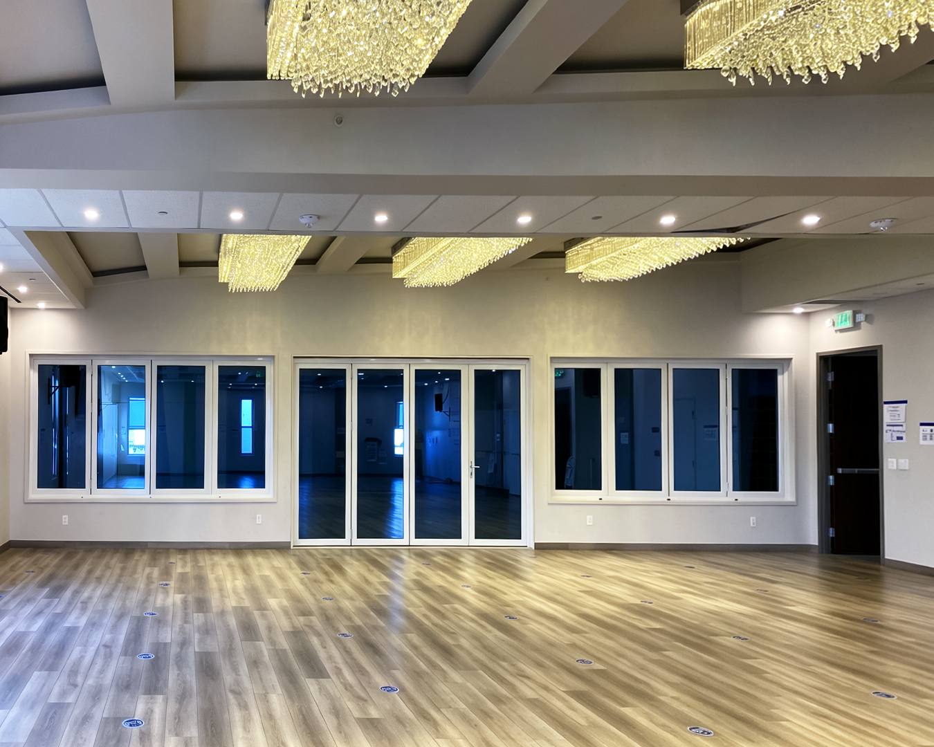 Georgia Windows & Doors white aluminum bi-fold doors and folding windows — full wall commercial hall installation blue tinted glazing Burlingame CA